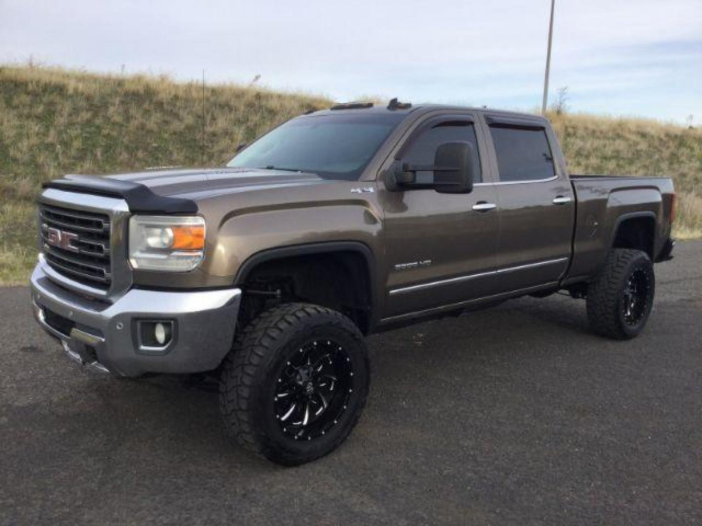 2015 Bronze Alloy Metallic /Cocoa/Dune GMC Sierra 3500HD SLT Crew Cab 4WD (1GT423E82FF) with an 6.6L V8 OHV 16 DIESEL engine, 6-Speed Automatic transmission, located at 1801 Main Street, Lewiston, 83501, (208) 743-9371, 46.417065, -117.004799 - Photo#0