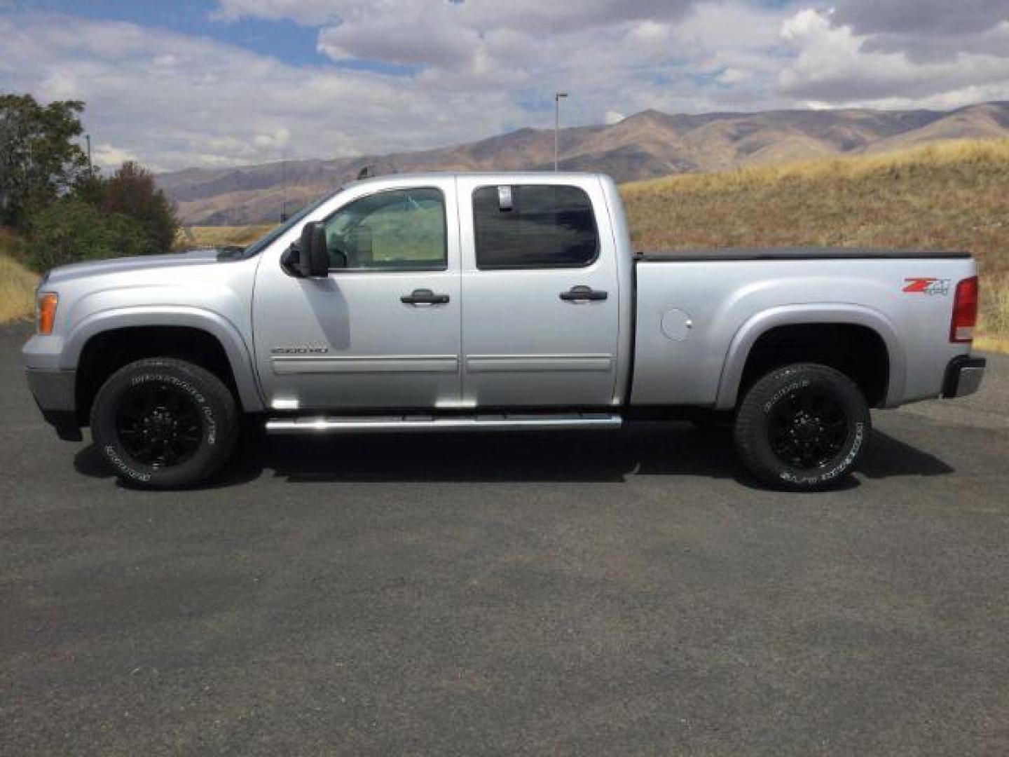 2013 Quicksilver Metallic /Ebony Cloth Interior GMC Sierra 2500HD SLE Crew Cab 4WD (1GT120C81DF) with an 6.6L V8 OHV 32V TURBO DIESEL engine, 6-Speed Automatic transmission, located at 1801 Main Street, Lewiston, 83501, (208) 743-9371, 46.417065, -117.004799 - Photo#1